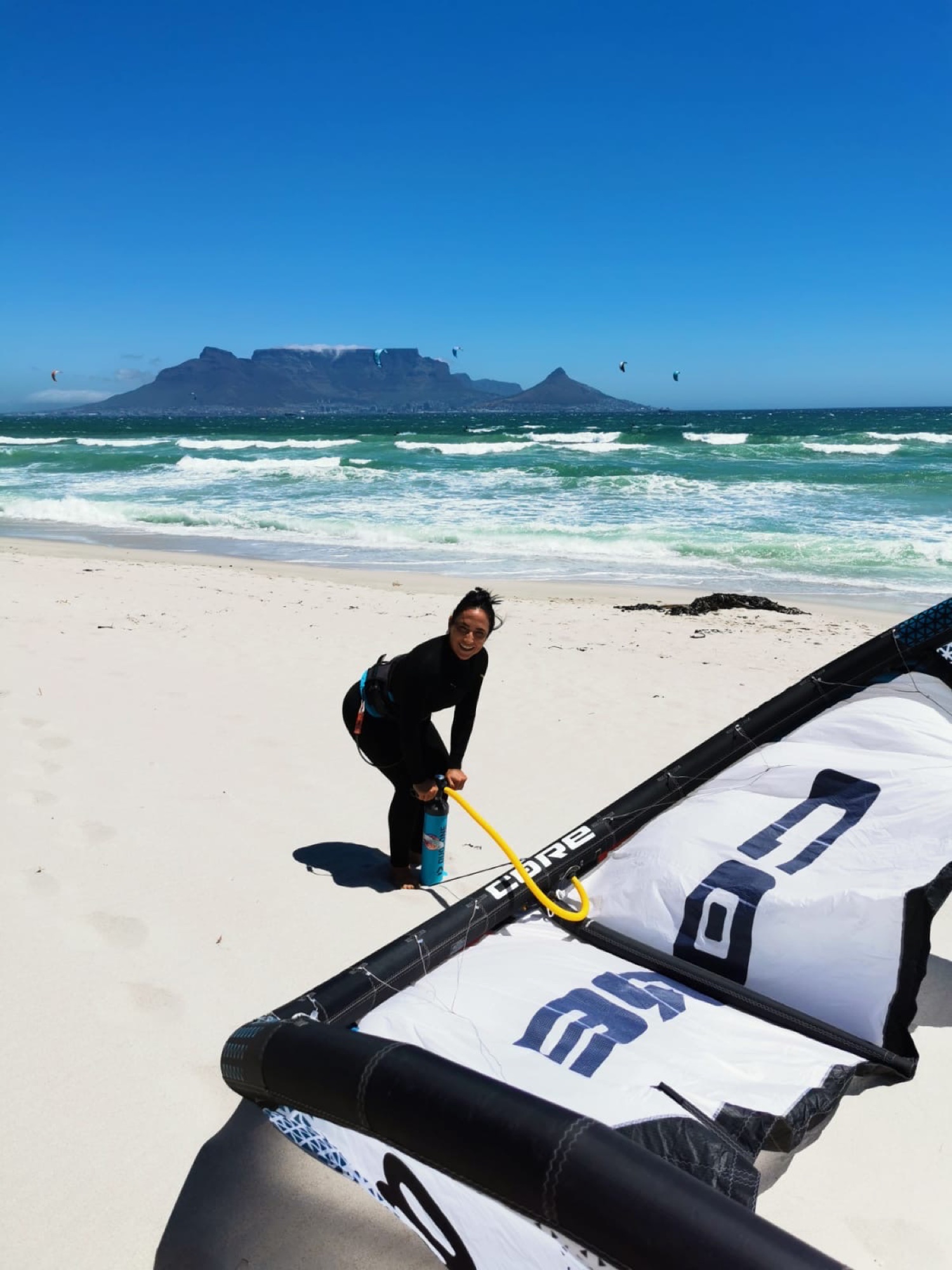 Kitesurfer pumping kite on Blouberg Beach with Table Mountain in background — Cape Town kite expedition Local Secrets XP