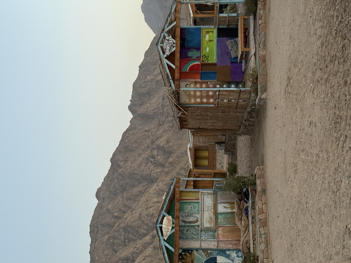 Colourful painted camp huts with Sinai mountains at dusk — Dahab Blue Lagoon