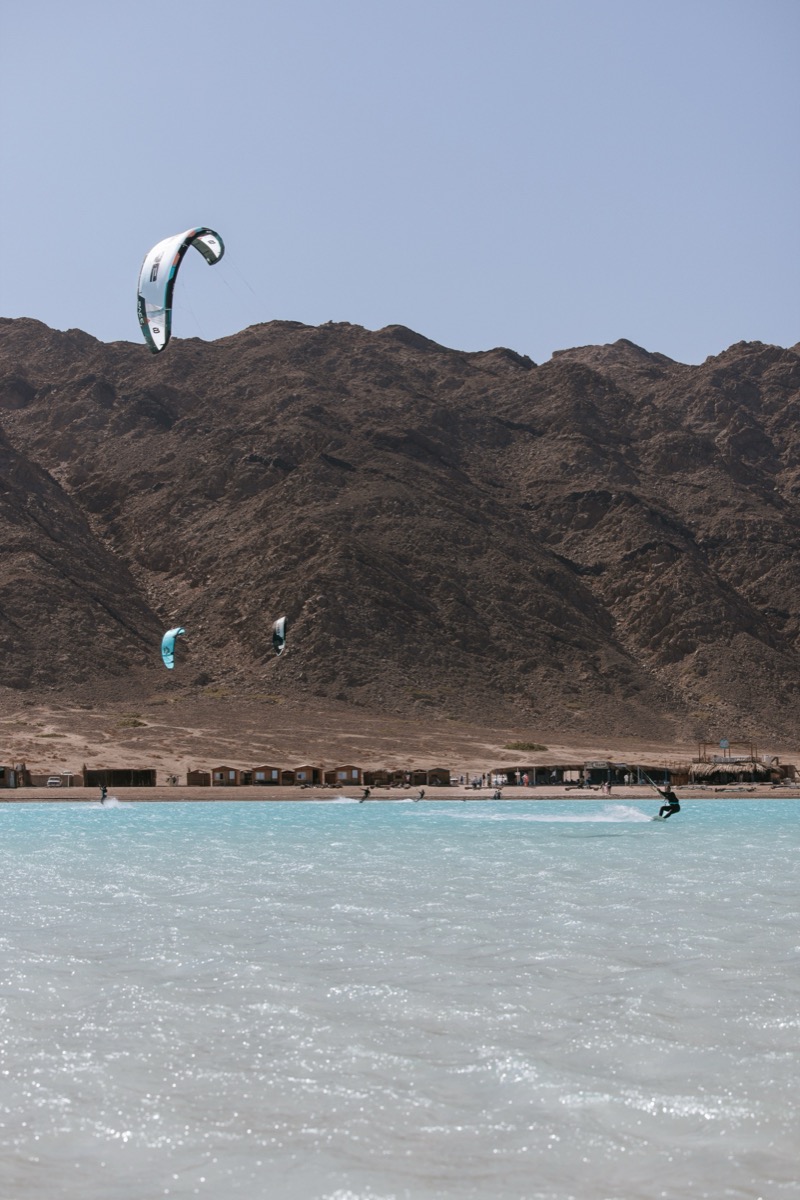 Kitesurfers riding the Blue Lagoon with Sinai mountains behind — Dahab kite expedition