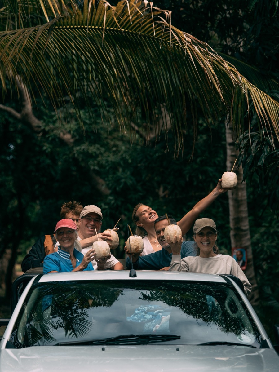 Expedition guests celebrating with fresh coconuts on Inhaca Island, Mozambique kite expedition