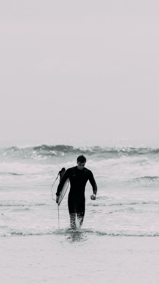 Kitesurfer walking out of the Indian Ocean waves on Inhaca Island, Mozambique